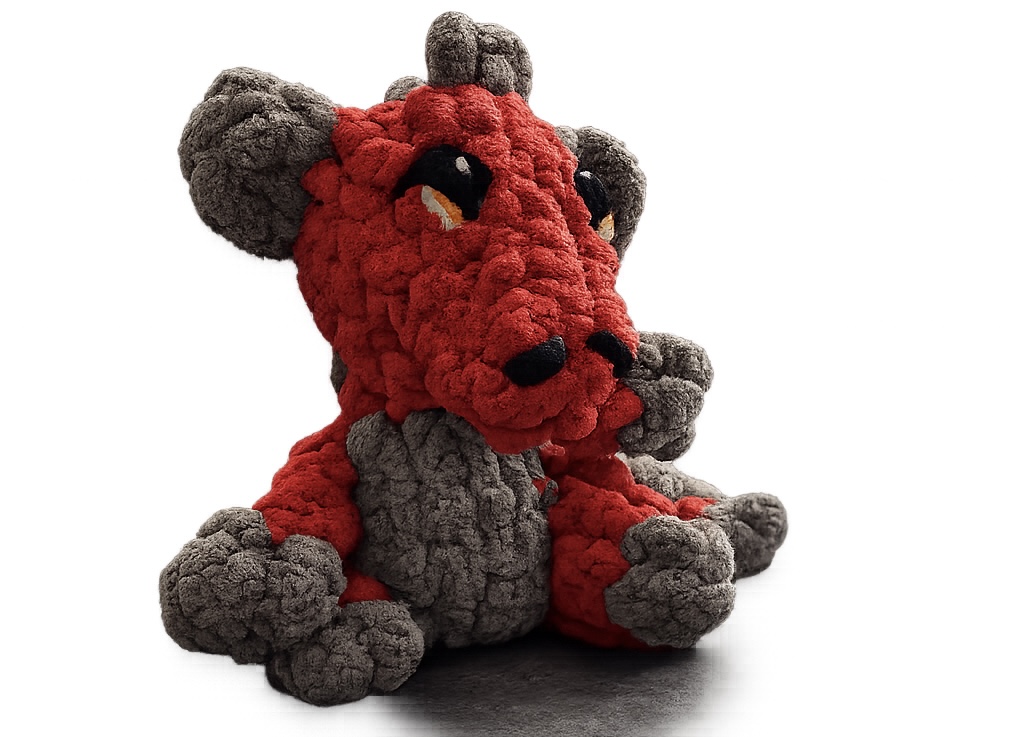 A red and gray finger-knit dragon stuffie sitting on a white backdrop.